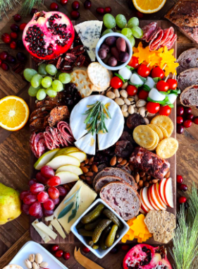 Holiday inspired charcuterie board with festive meats, cheeses, and fruit