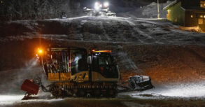 Groomer cabin cat with skis inside and another groomer behind it