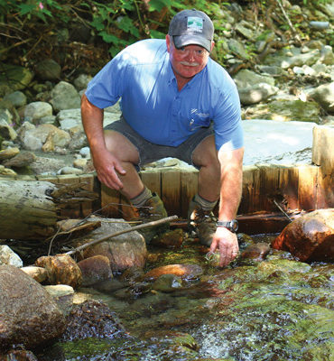 Gene Martin collecting water samples from Clay Brook