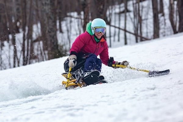 Adaptive skier on groomer